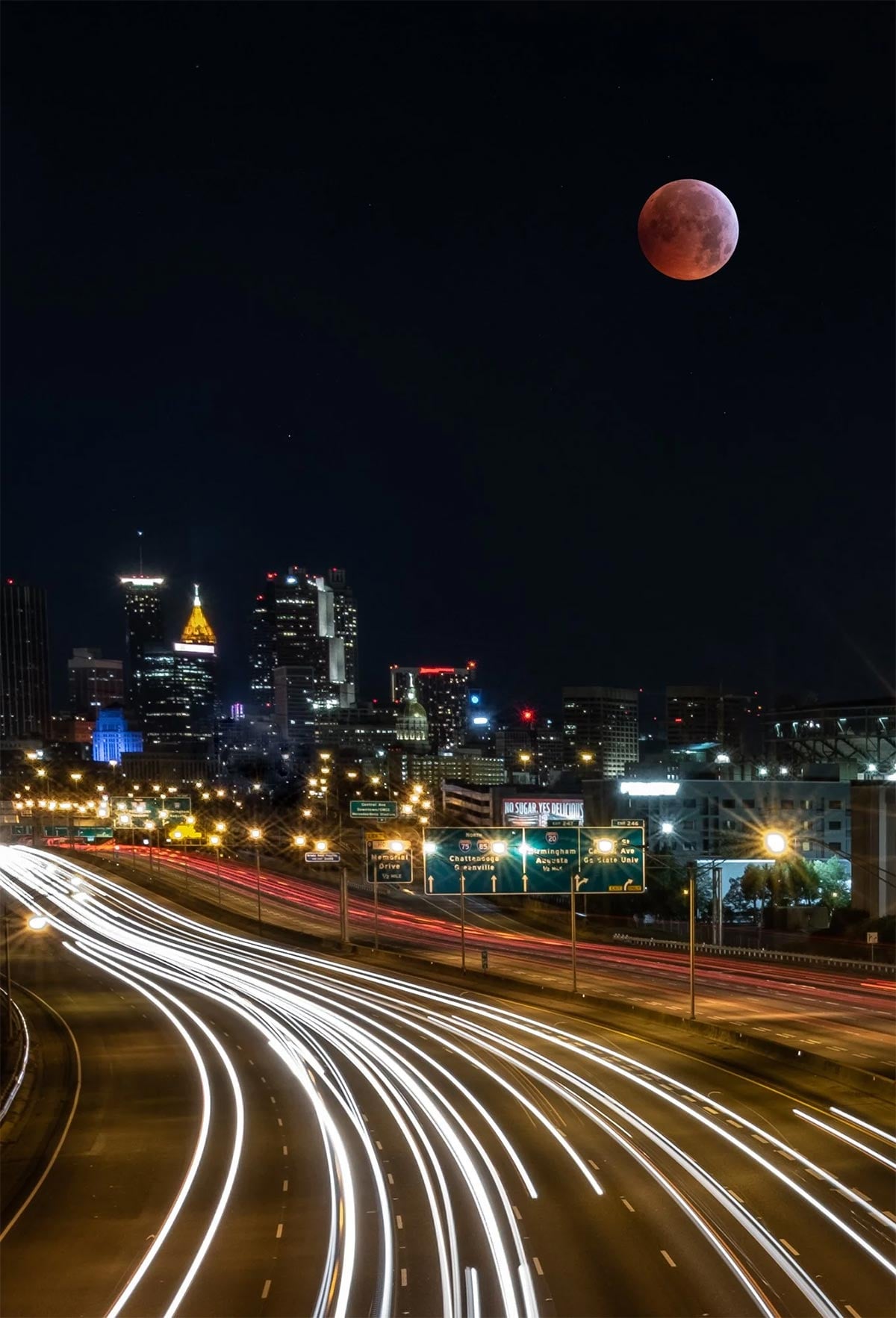 blood moon eclipse over a city skyline